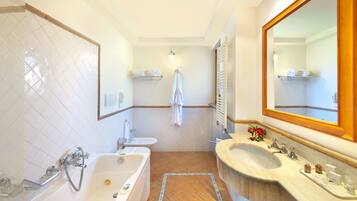 Une salle de bain avec une baignoire, un lavabo et un miroir.