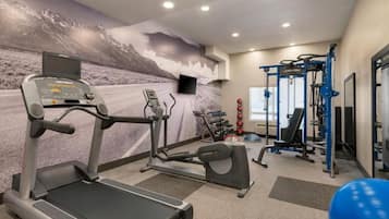 A gym with treadmills, elliptical machines, and weightlifting equipment.