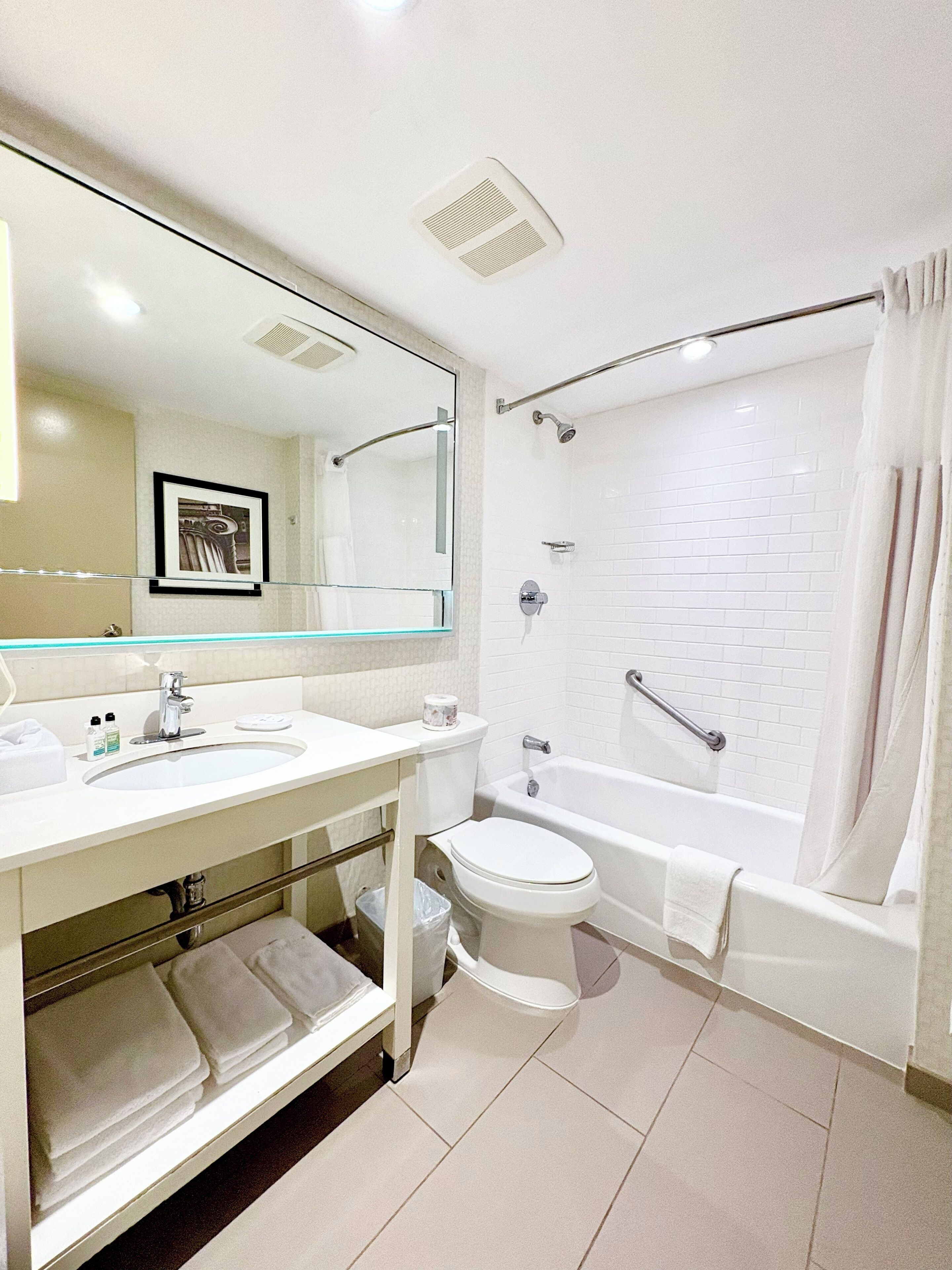 Une salle de bain moderne avec un lavabo, des toilettes et une baignoire, le tout de couleur blanche.