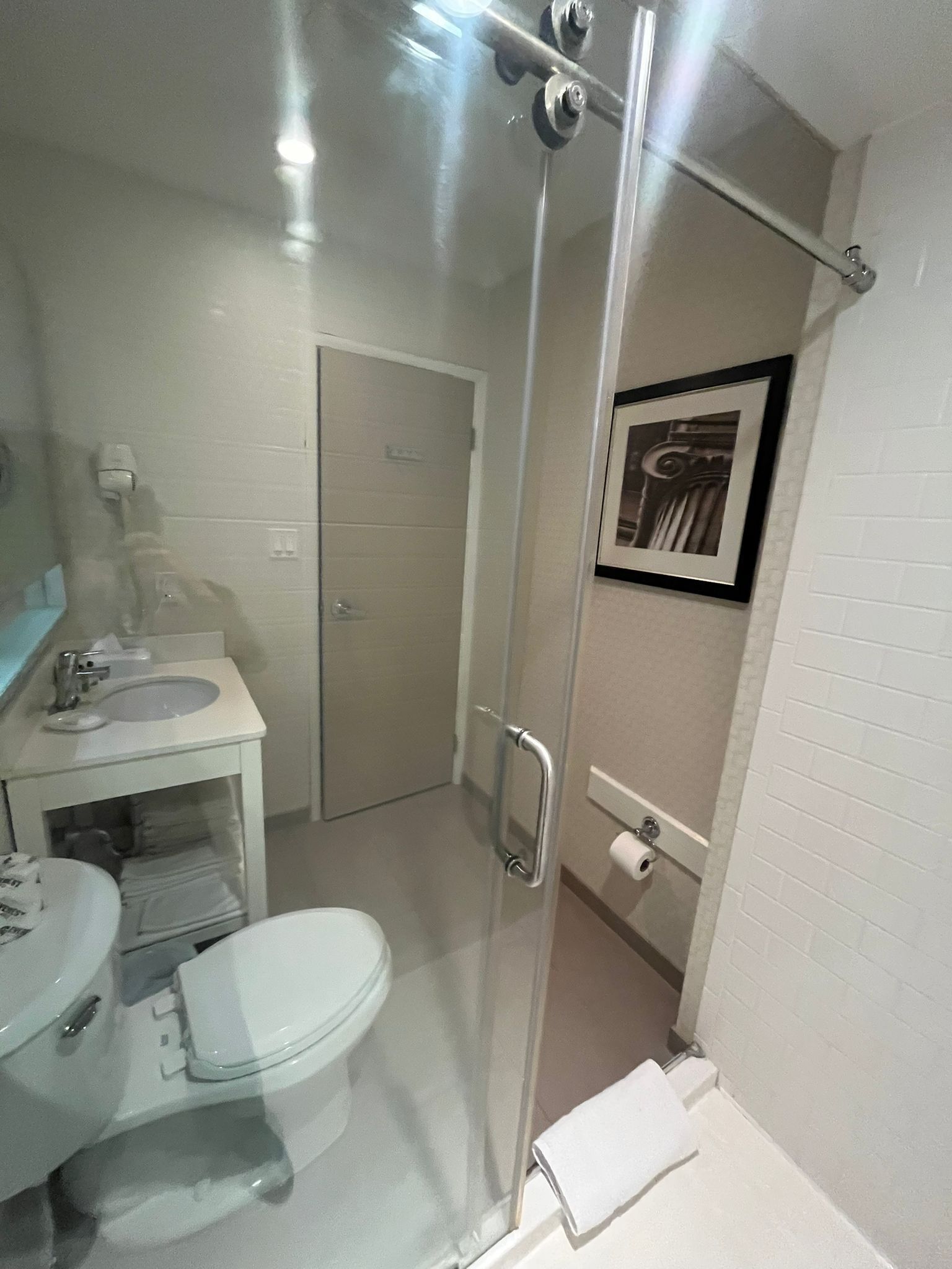 A bathroom with a toilet, sink, and shower.