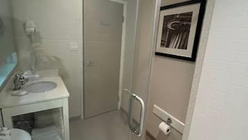 A bathroom with a toilet, sink, and shower.