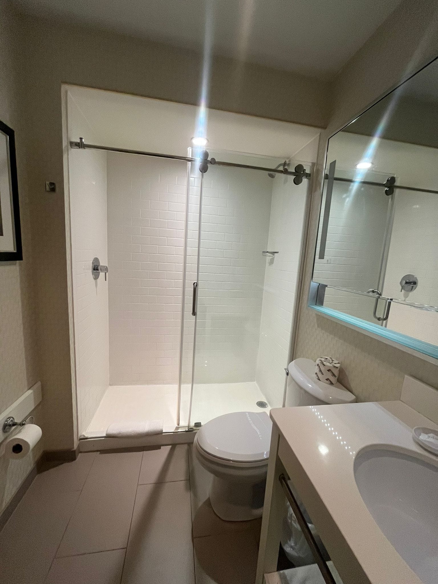 Un baño moderno con ducha de vidrio, inodoro y lavamanos.