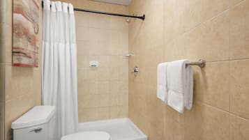 Un baño con ducha, inodoro y perchero para toallas.