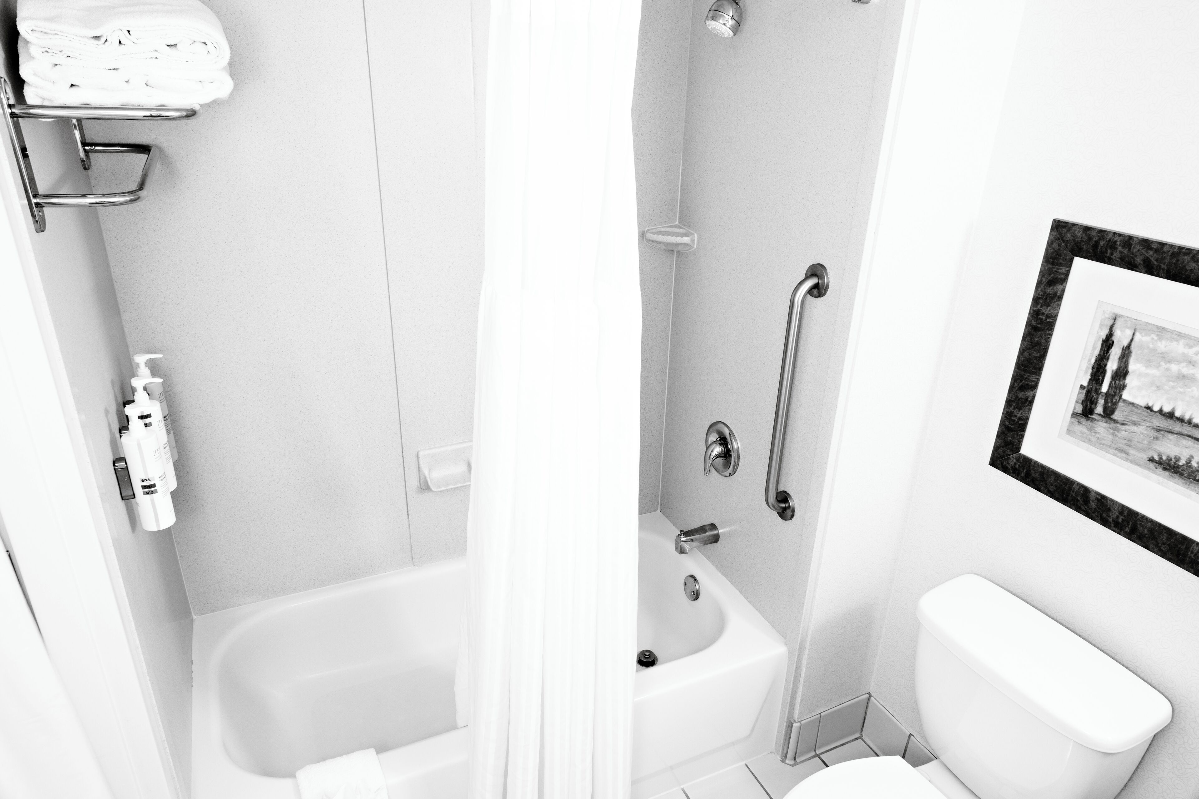 A bathroom with a bathtub, a toilet, and a shower area.