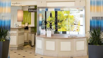 Un espace d’accueil comprenant un comptoir, une vitrine et une enseigne placée au-dessus.