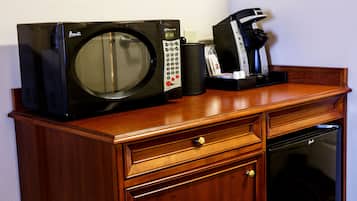 Un microondas, cafetera y lavavajillas sobre una encimera de madera.