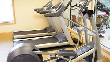 Un gimnasio con cintas de correr y una bicicleta estática.