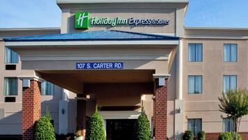 A Holiday Inn Express & Suites building with a clear sign indicating the address 107 S. Carter Rd.