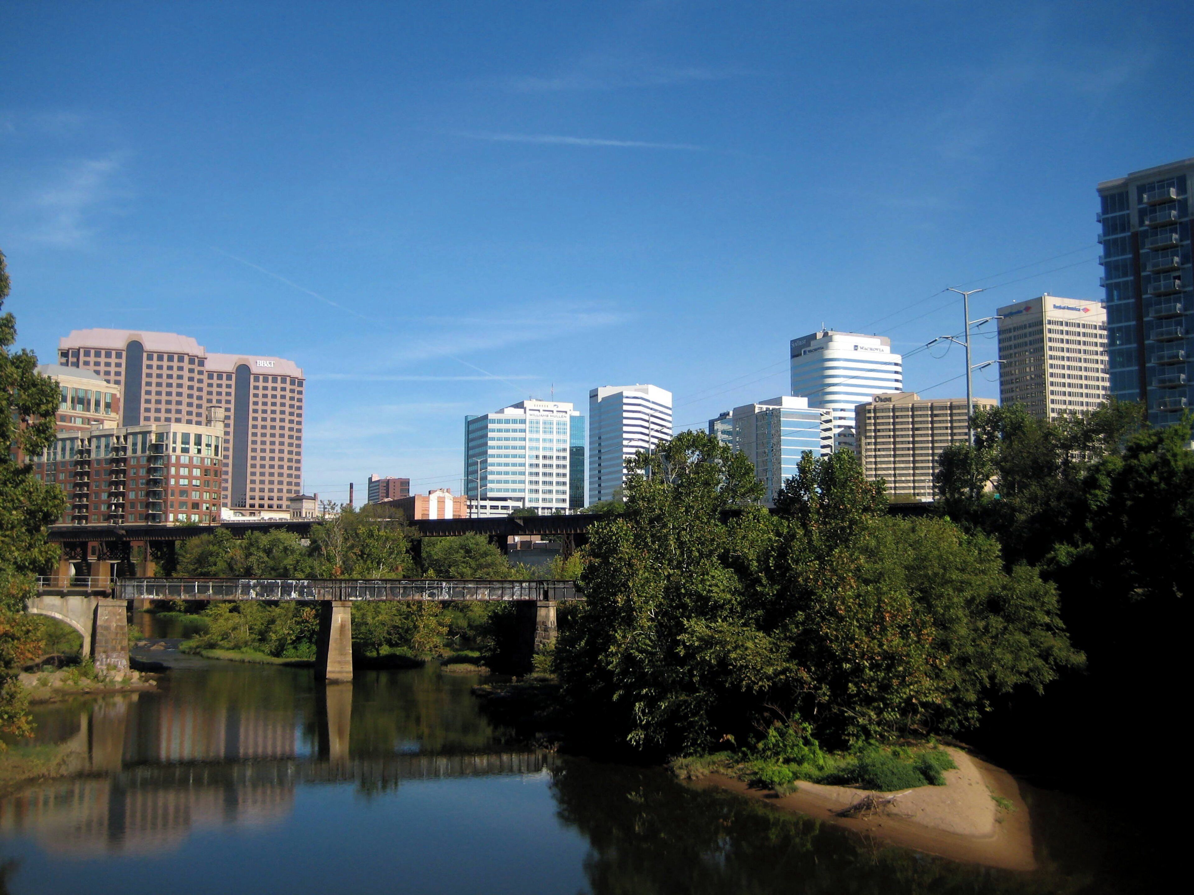 A cityscape with modern high-rise buildings, a river, and a bridge.