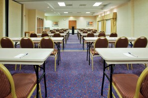 A conference room with rows of tables and chairs, a carpeted floor, and a podium at the front. - Holiday Inn Express Hotel & Suites Richmond North Ashland by IHG (Ashland)