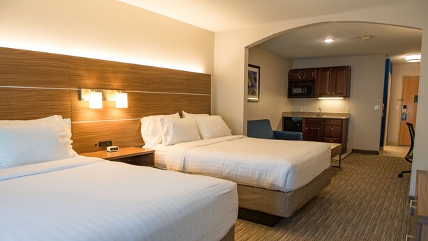 A hotel room with two beds, a nightstand, a desk, and a kitchenette. - Holiday Inn Express & Suites Elkhart by IHG (Elkhart)