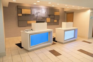 A reception area with two reception desks, a wall-mounted sign, and a door.