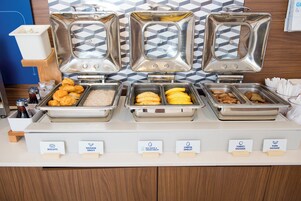 A buffet with labeled food options including biscuits, sausage gravy, egg white & veggie omelet, cheese omelet, turkey sausage, and pork sausage.