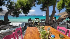A wooden table with chairs and a view of the sea. - Lakki Village (Amorgos)