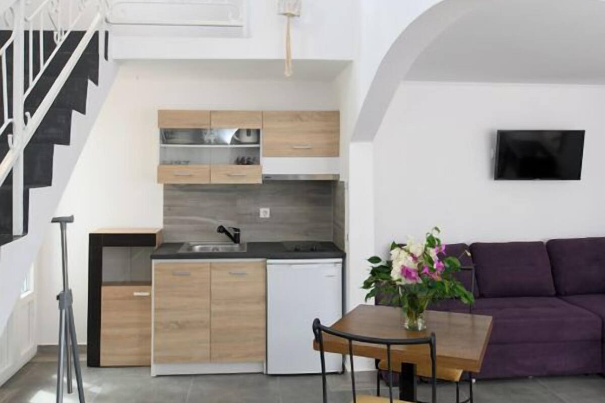 Eine moderne Küche mit Holzausstattung, einem Einbauherd und einem Essbereich mit Tisch und Stühlen.