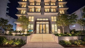 A multi-story hotel with a central entrance, surrounded by landscaped areas and trees. - Sanctuary South Beach (MIAMI BEACH)