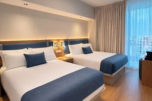 A hotel room with two beds, a nightstand, and a view of the city. - Sanctuary South Beach (MIAMI BEACH)