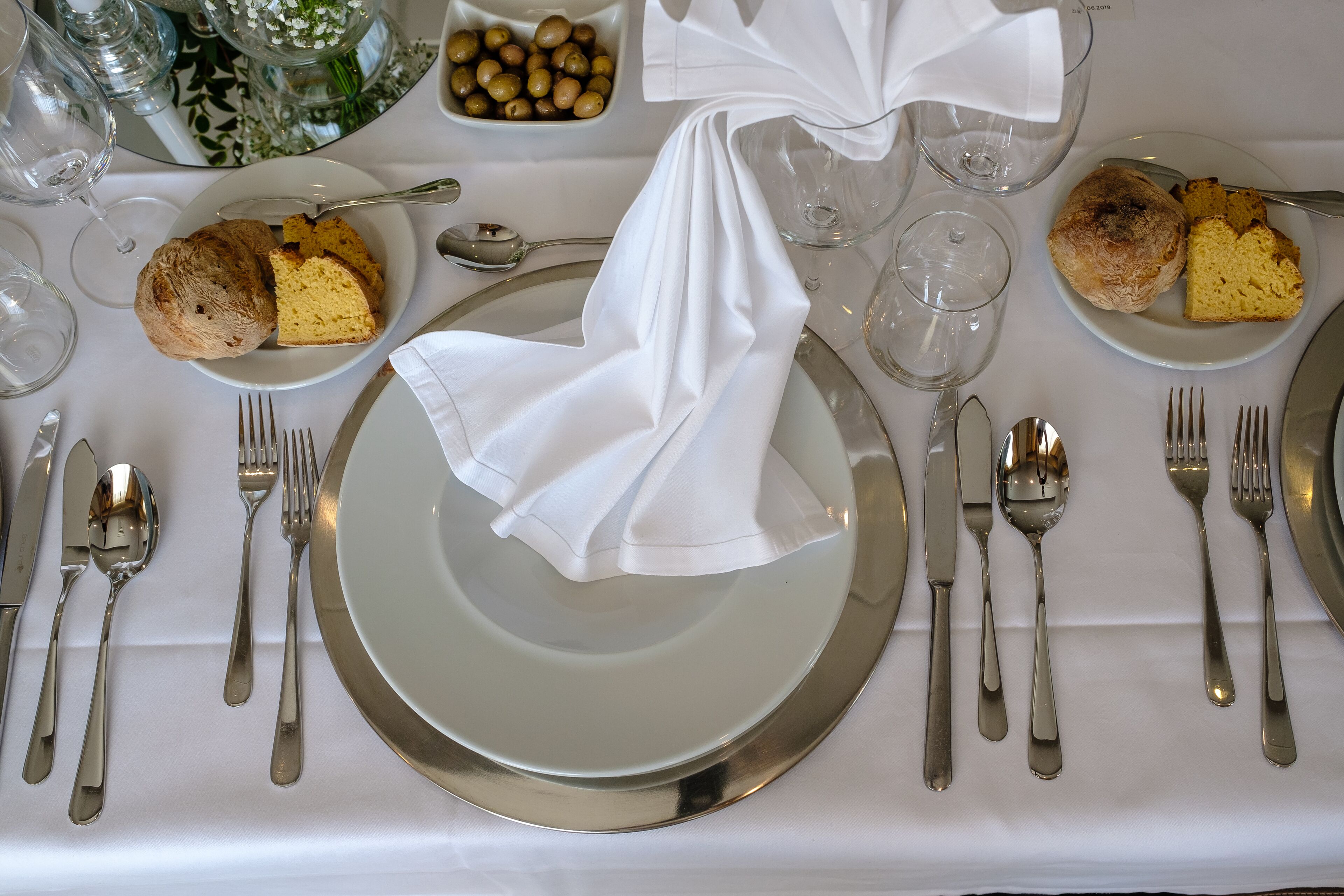 A table set for a meal with plates, silverware, and glasses.
