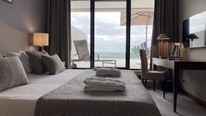 Habitación de hotel con cama, escritorio y silla. Se aprecia vista al exterior a través de la ventana.