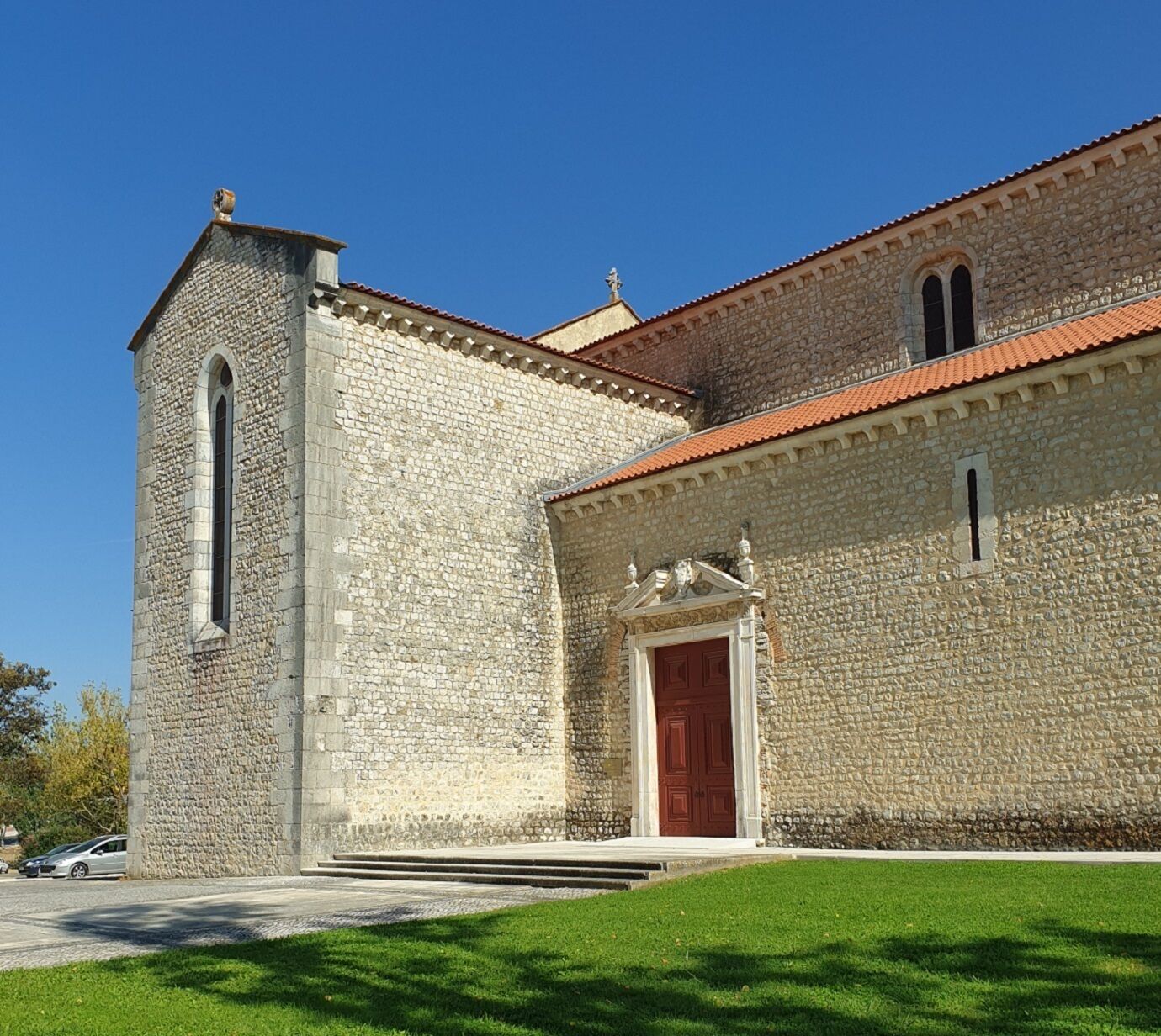 Un edificio de piedra con una puerta roja y una torre alta.