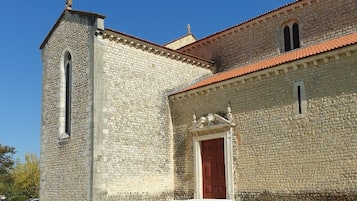 Un edificio de piedra con una puerta roja y una torre alta.