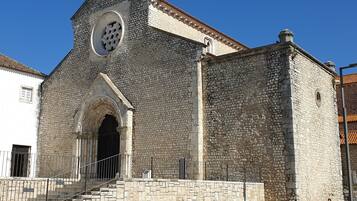 A stone building with a large circular window and an arched entrance.