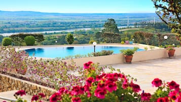 Una piscina techada, una piscina al aire libre de temporada, sombrillas