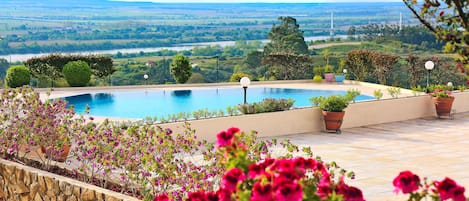 Una piscina techada, una piscina al aire libre de temporada, sombrillas