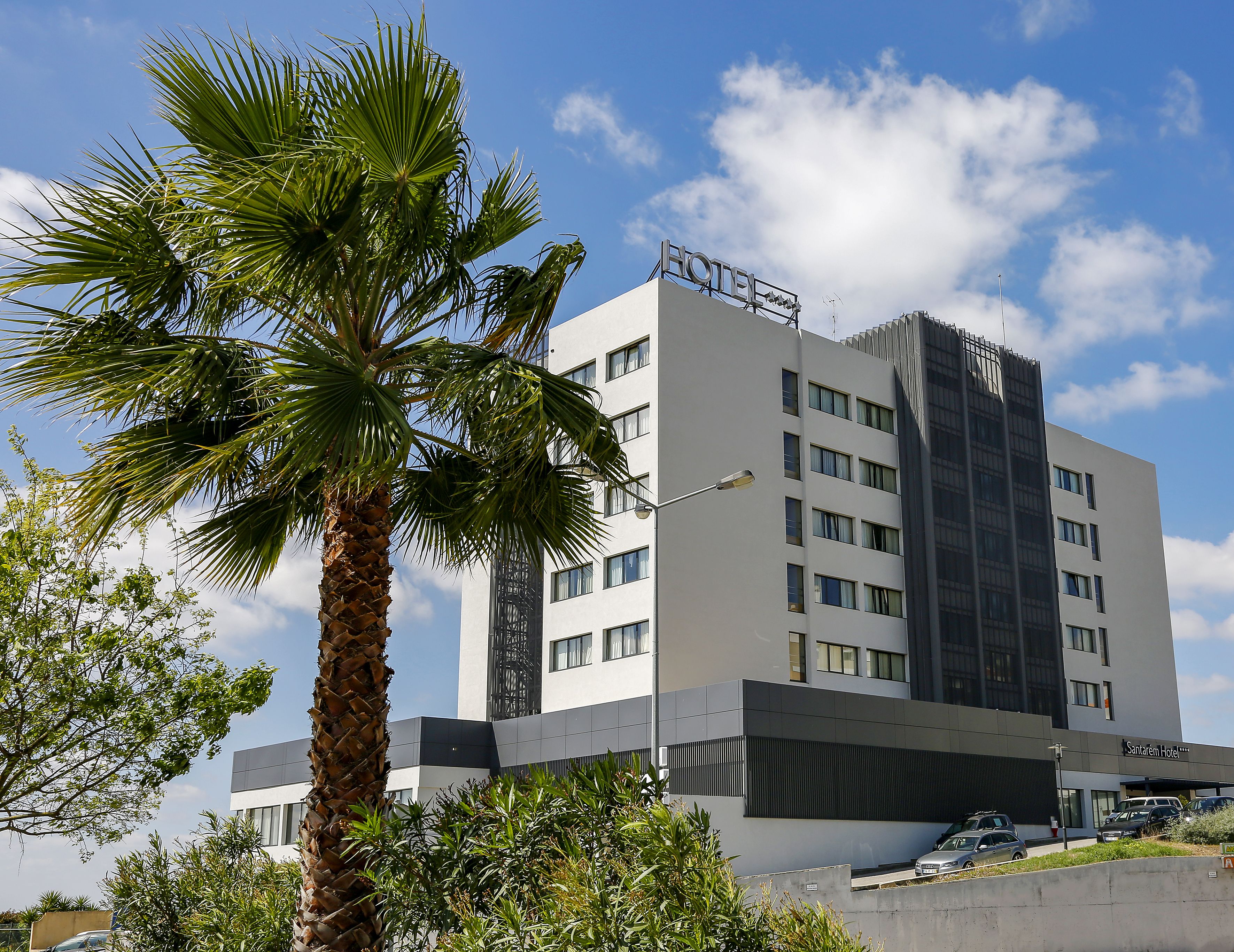 A modern hotel with a flat roof, multiple windows, and a sign indicating it is a hotel.
