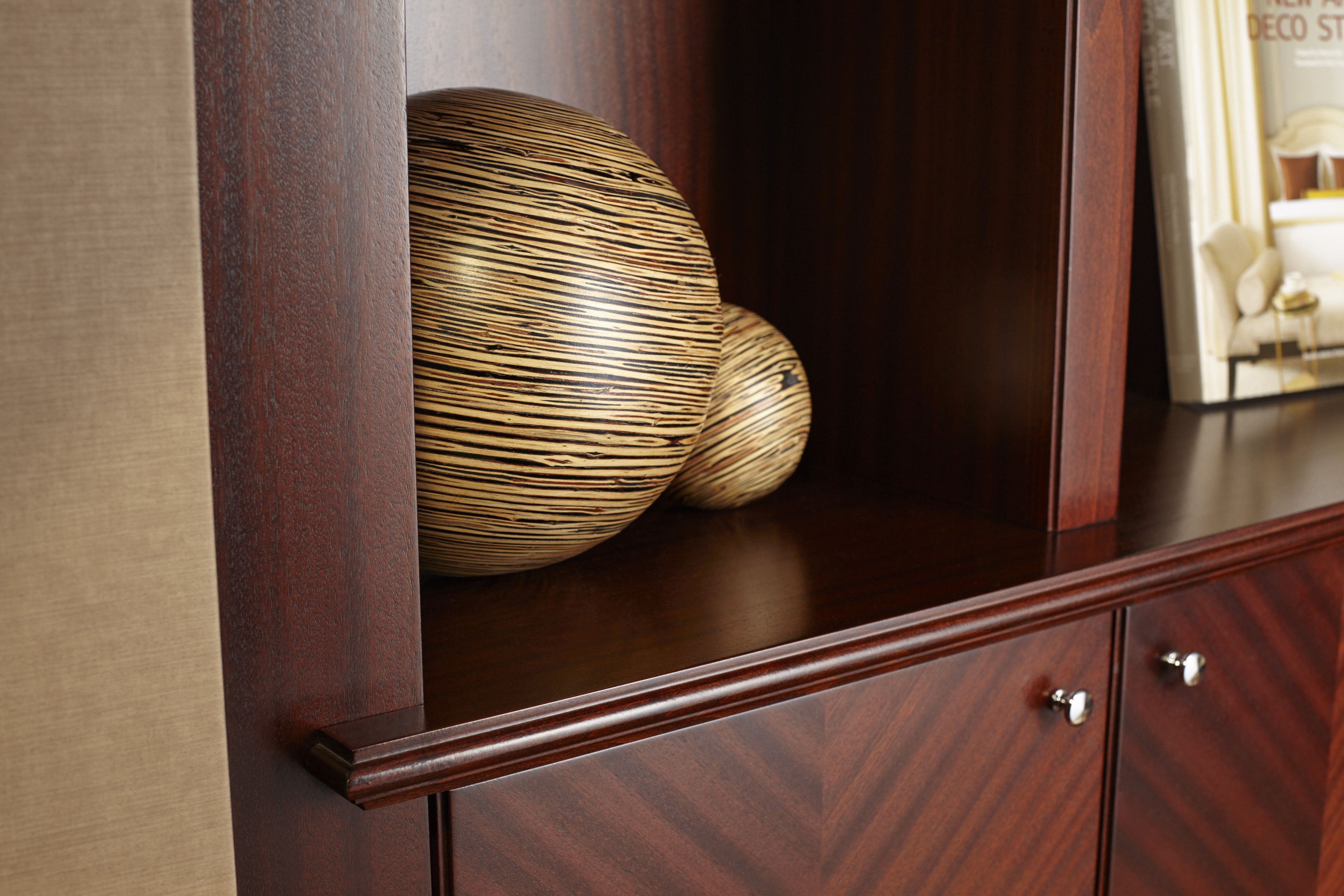 A wooden cabinet with two spherical objects and a magazine on top.