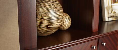 A wooden cabinet with two spherical objects and a magazine on top.