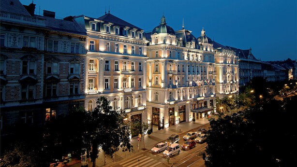 Un hotel grande e histórico con varios pisos, arquitectura ornamentada y una cúpula destacada.