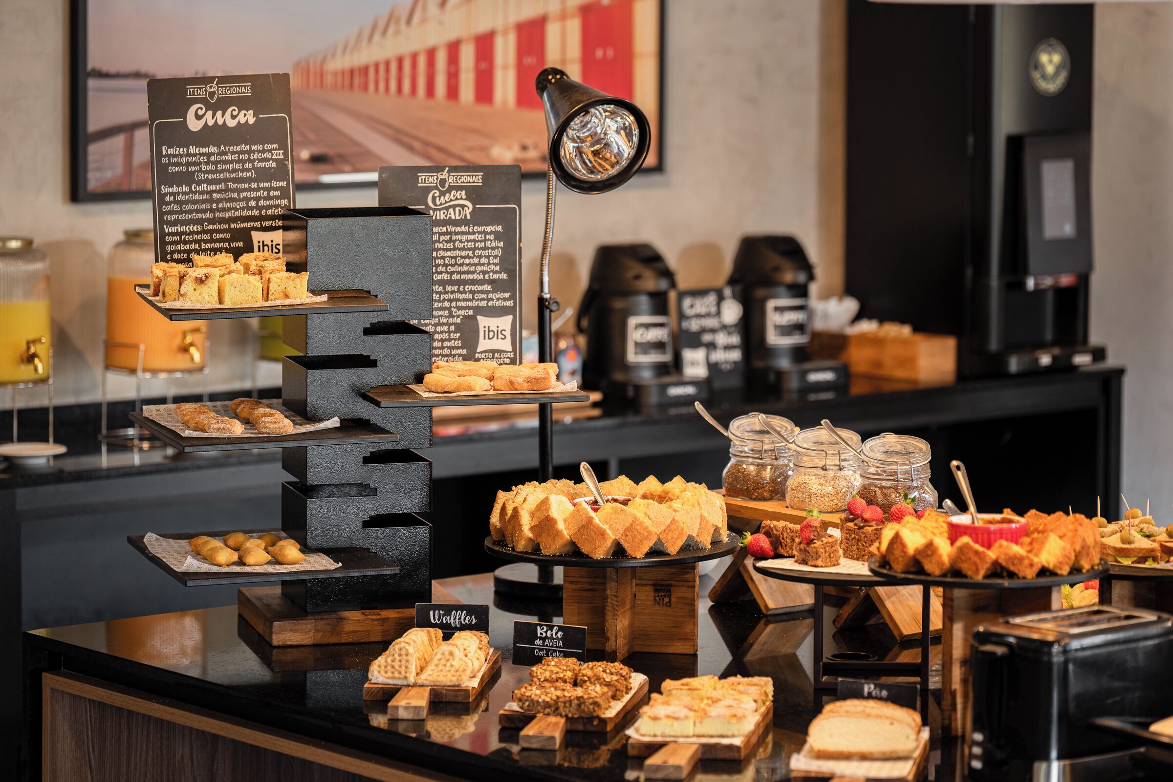 Ein Buffet mit verschiedenen Speisen und einem Schild mit der Aufschrift 'Cuca' und einer Beschreibung des Angebots.
