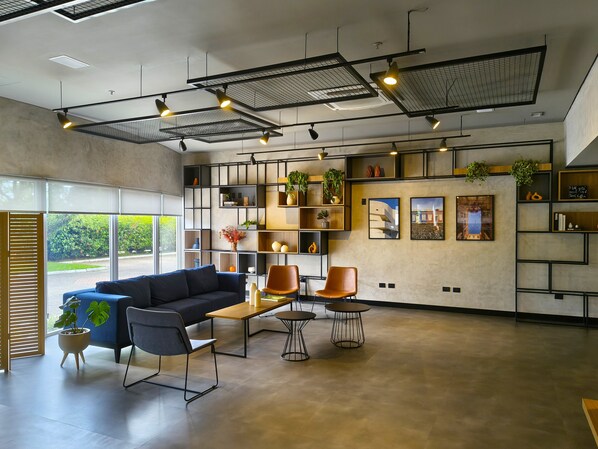 A modern interior with a sofa, chairs, a coffee table, and a bookshelf.