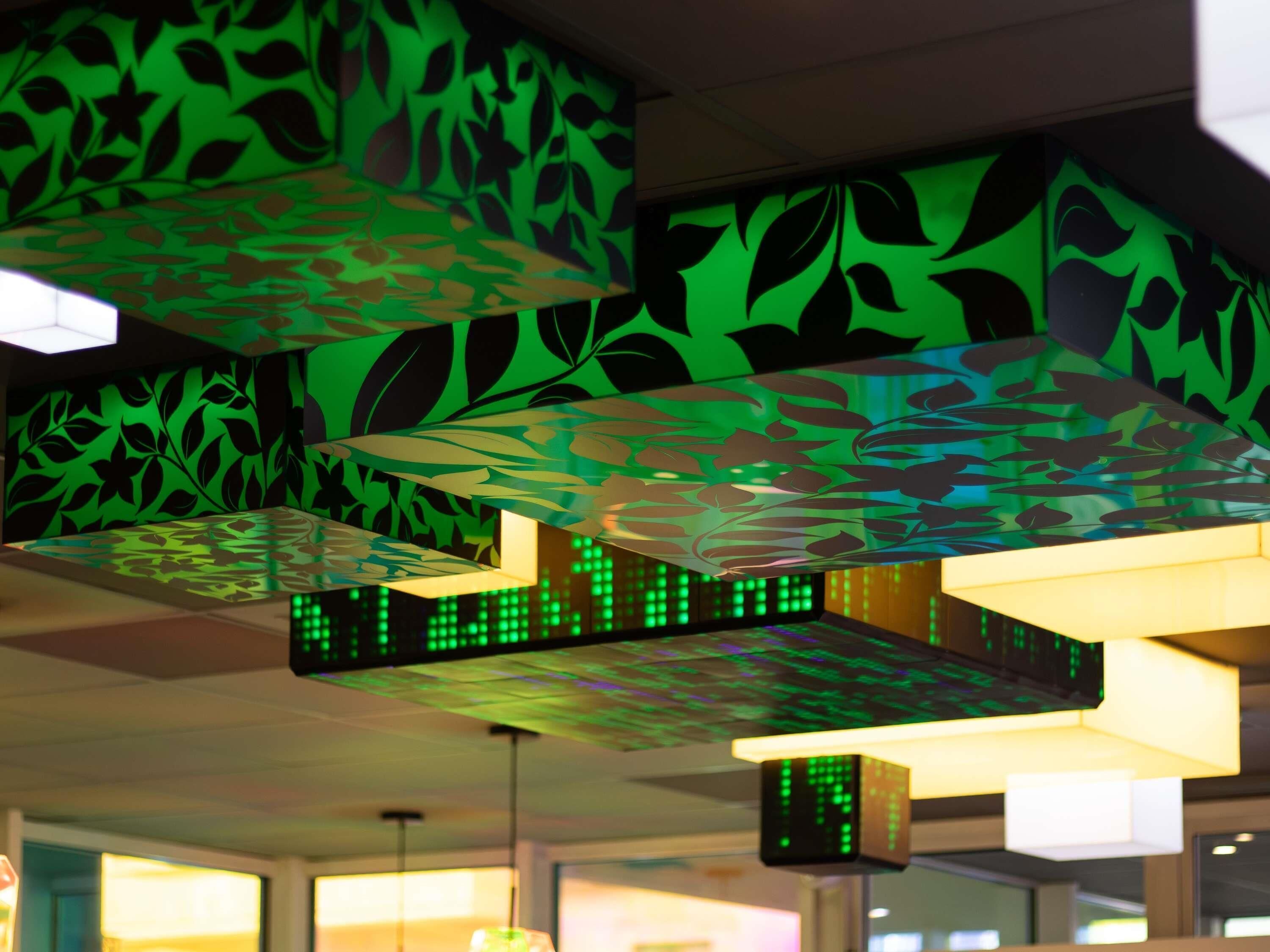 Un plafond orné de motifs géométriques et doté d’un écran numérique.