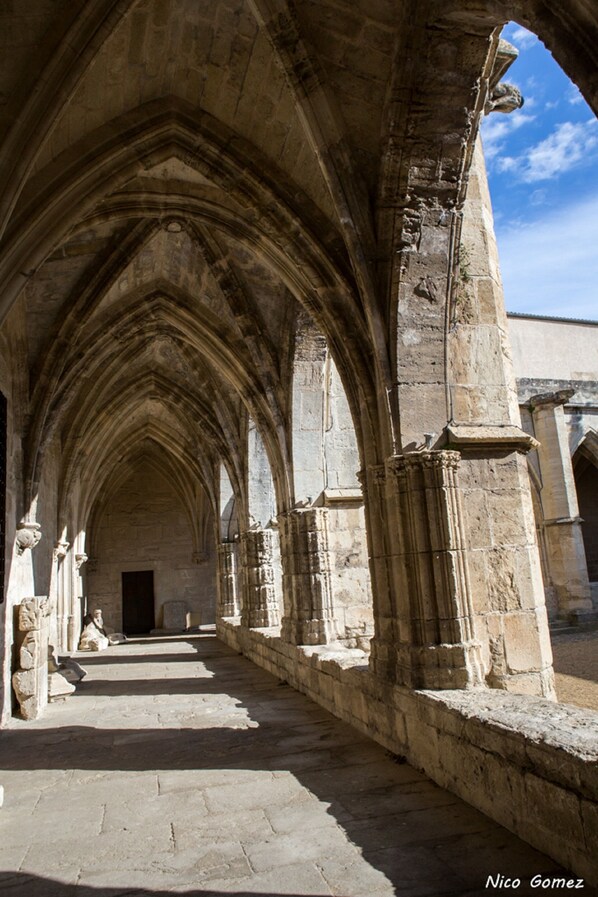 A cathedral's interior with a long, arched corridor and stone columns.