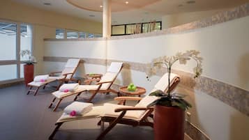 Unwind in a serene indoor space with plush lounge chairs, small tables, and a beautiful mosaic border.