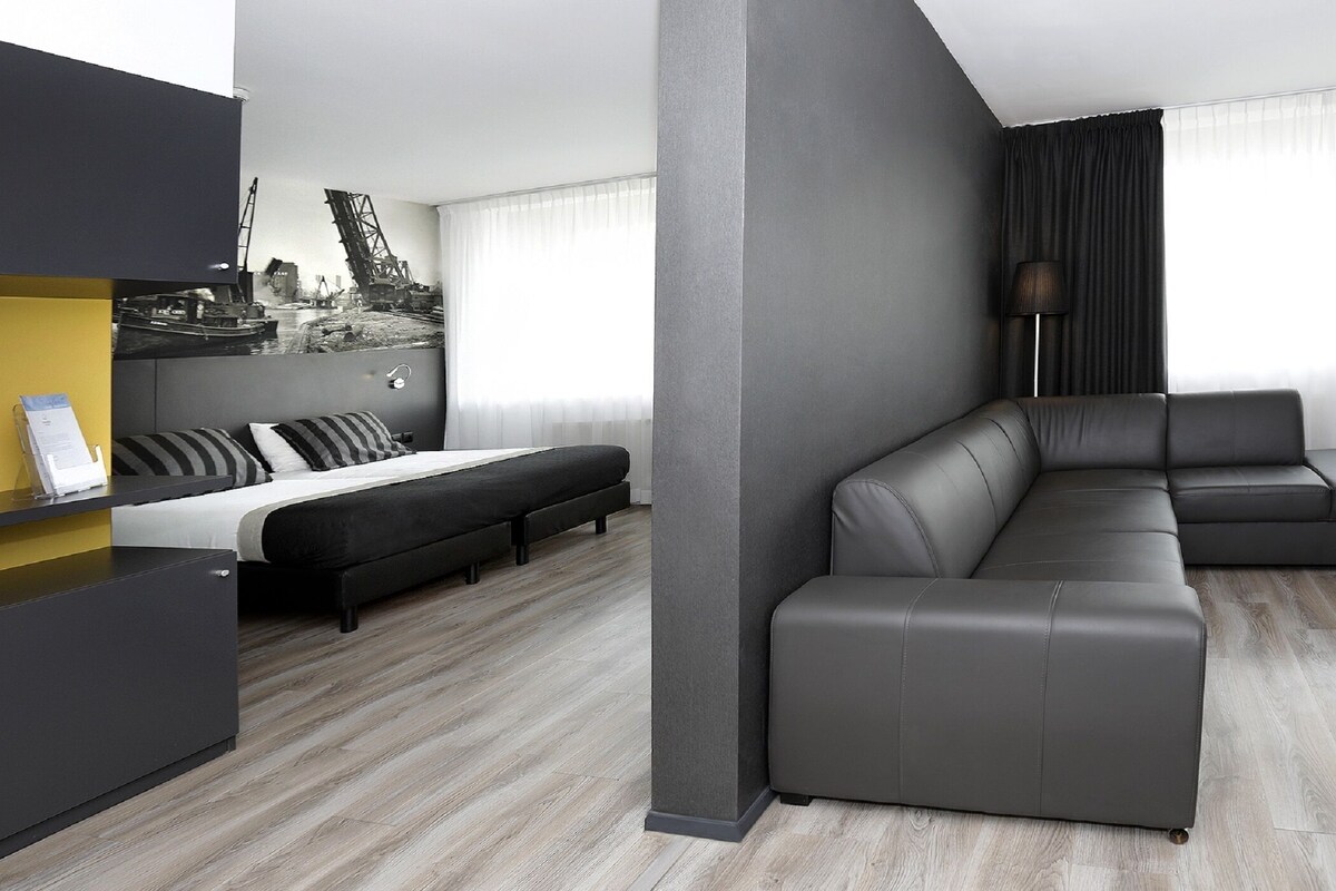Un salon moderne avec un canapé, un lit et une armoire intégrée.