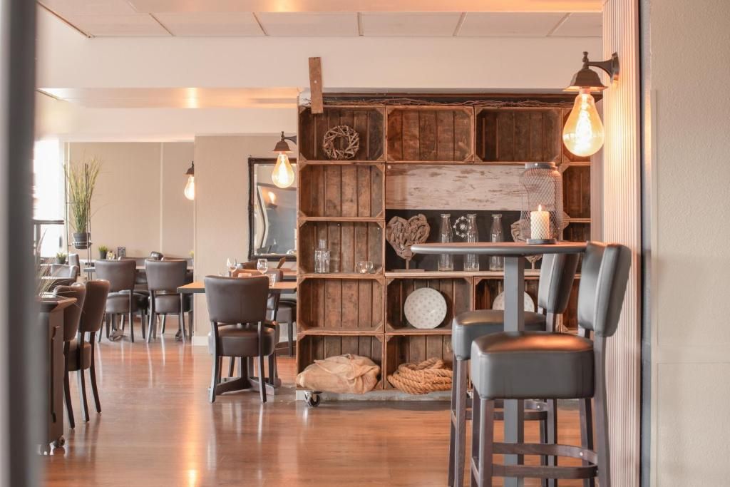 L'intérieur d'un restaurant, avec des étagères, des tables et des chaises en bois.