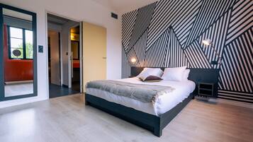 Un dormitorio moderno con una cama grande, un diseño de pared con estampado geométrico y un estilo minimalista.
