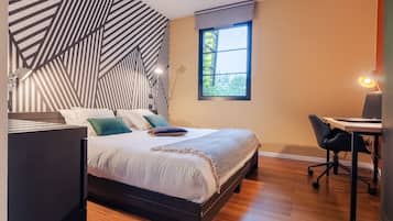 Ein Schlafzimmer mit Bett, Schreibtisch und Stuhl.