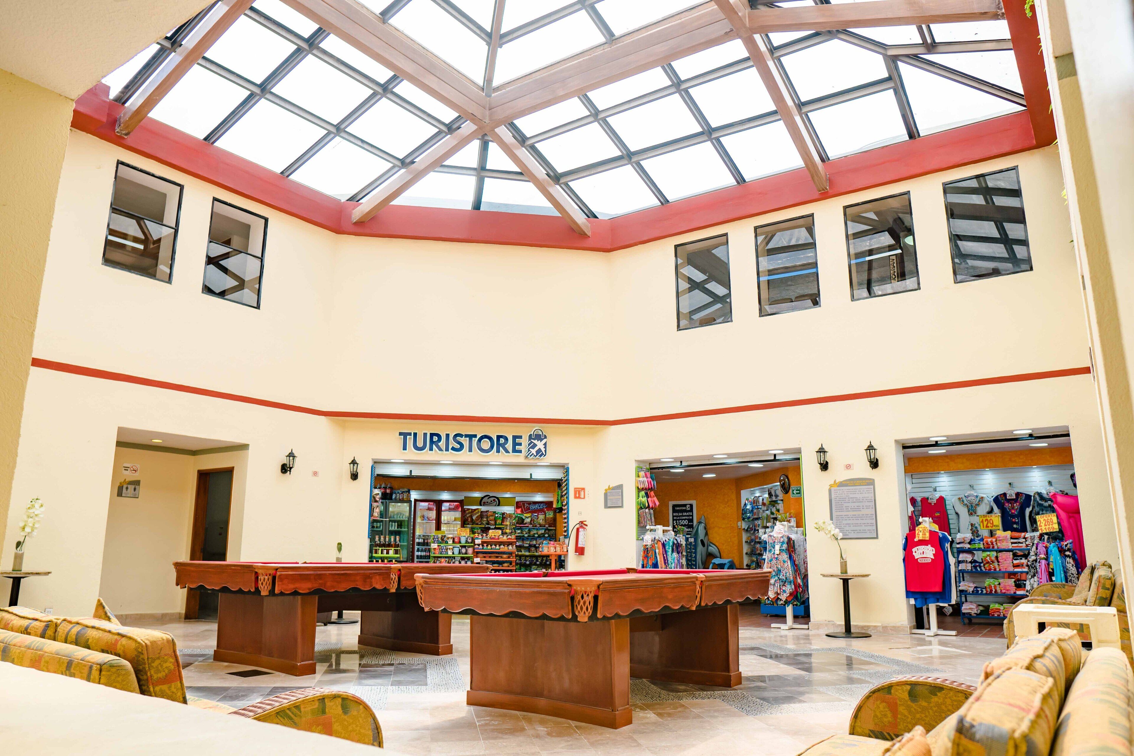 A spacious lobby with a pool table, a billiards table, and a 'Turiststore' sign.