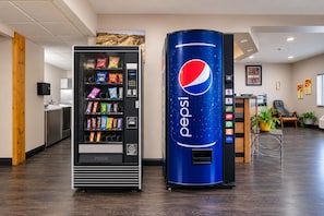 A vending machine with a Pepsi logo and a snack vending machine with various snacks.
