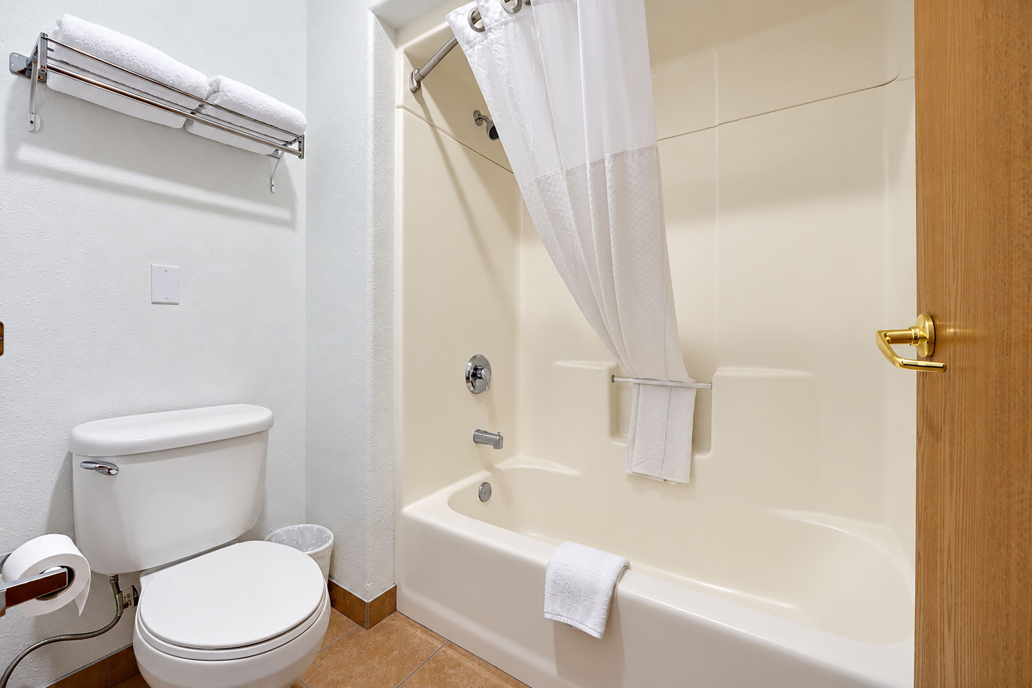 Un baño con inodoro, bañera y cortina de ducha.