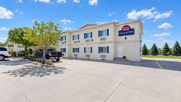 A two-story hotel with a sign for 'Inn & Suites' and a parking lot in front.