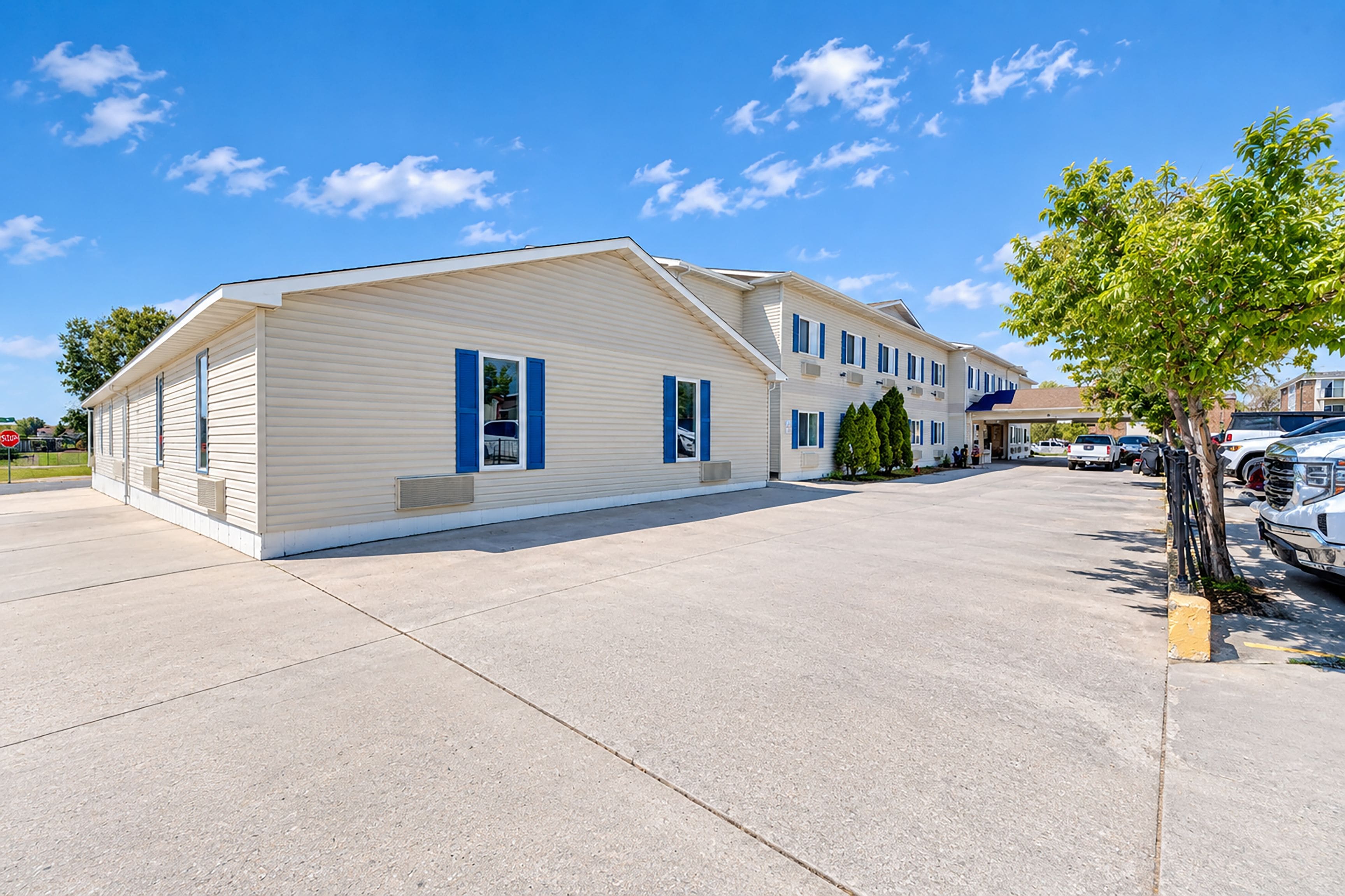 A two-story building with a flat roof and a parking lot in front.