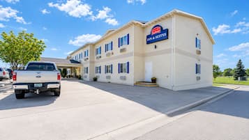 A two-story building with a sign for 'Fairbridge Inn & Suites.' There is a white pickup truck parked in front.