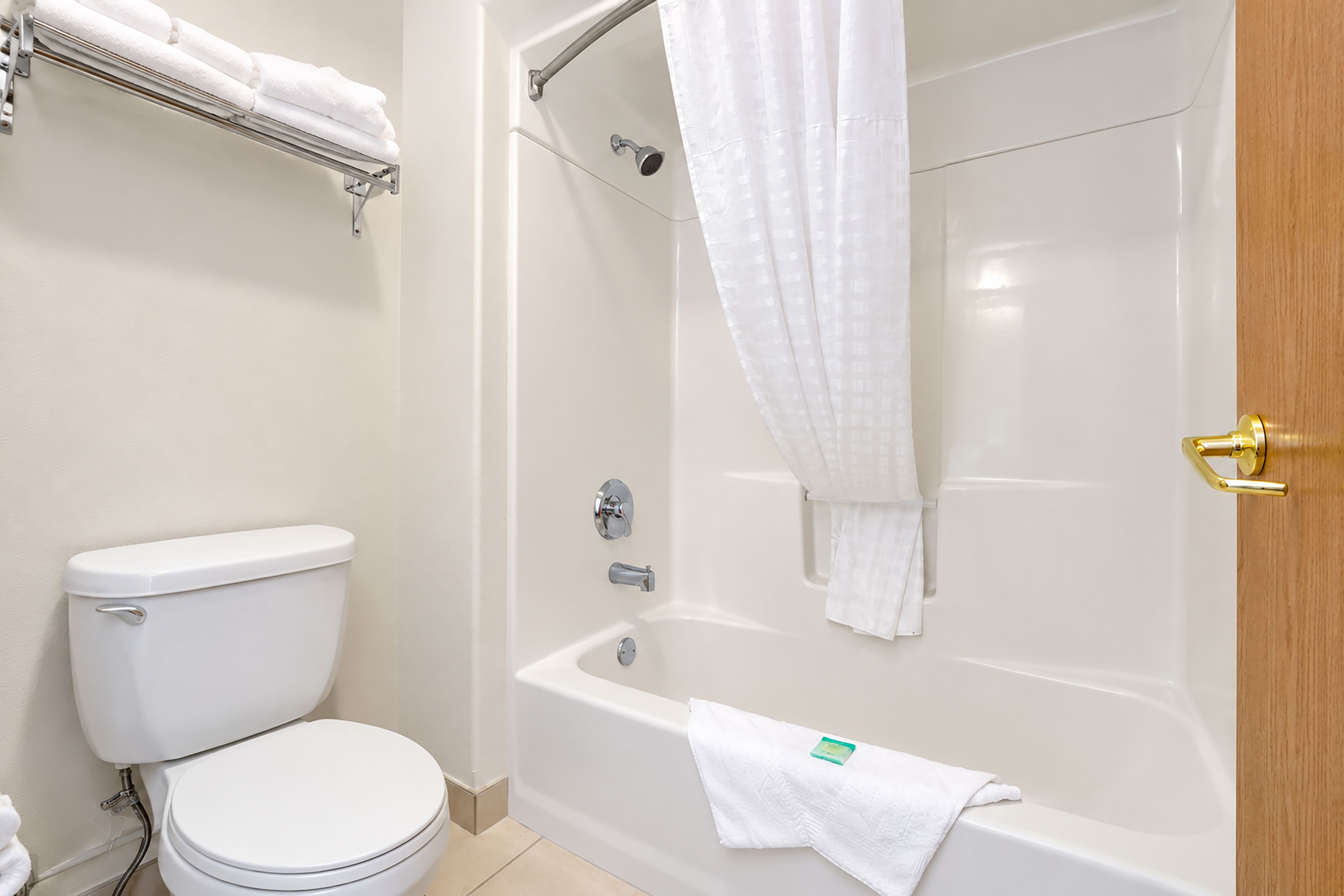 Un baño con inodoro, bañera y cortina de ducha.