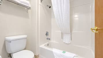Un baño con inodoro, bañera y cortina de ducha.