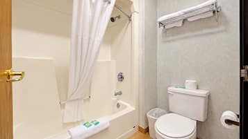 A bathroom with a bathtub, toilet, and a towel rack.